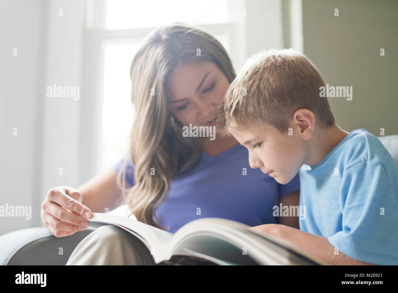 Mother and son reading a book together. Stock Photo