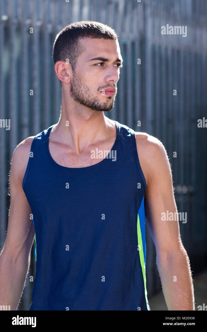 Young man in blue vest looking away, portrait. Stock Photo