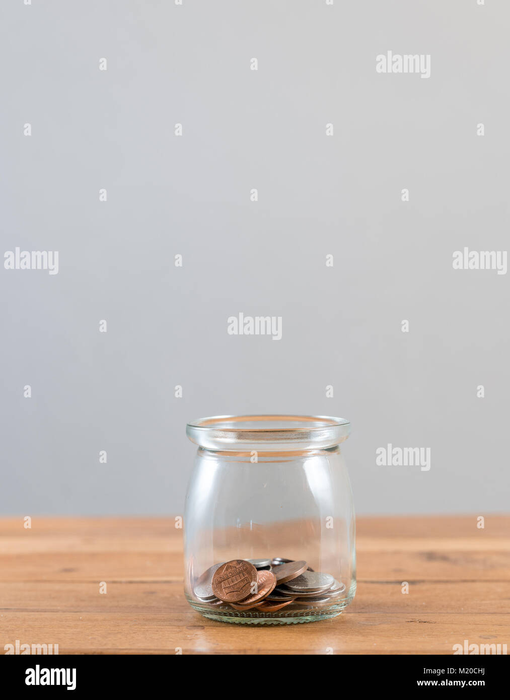 Loose change inside glass jar to represent retirement savings   Stock Photo