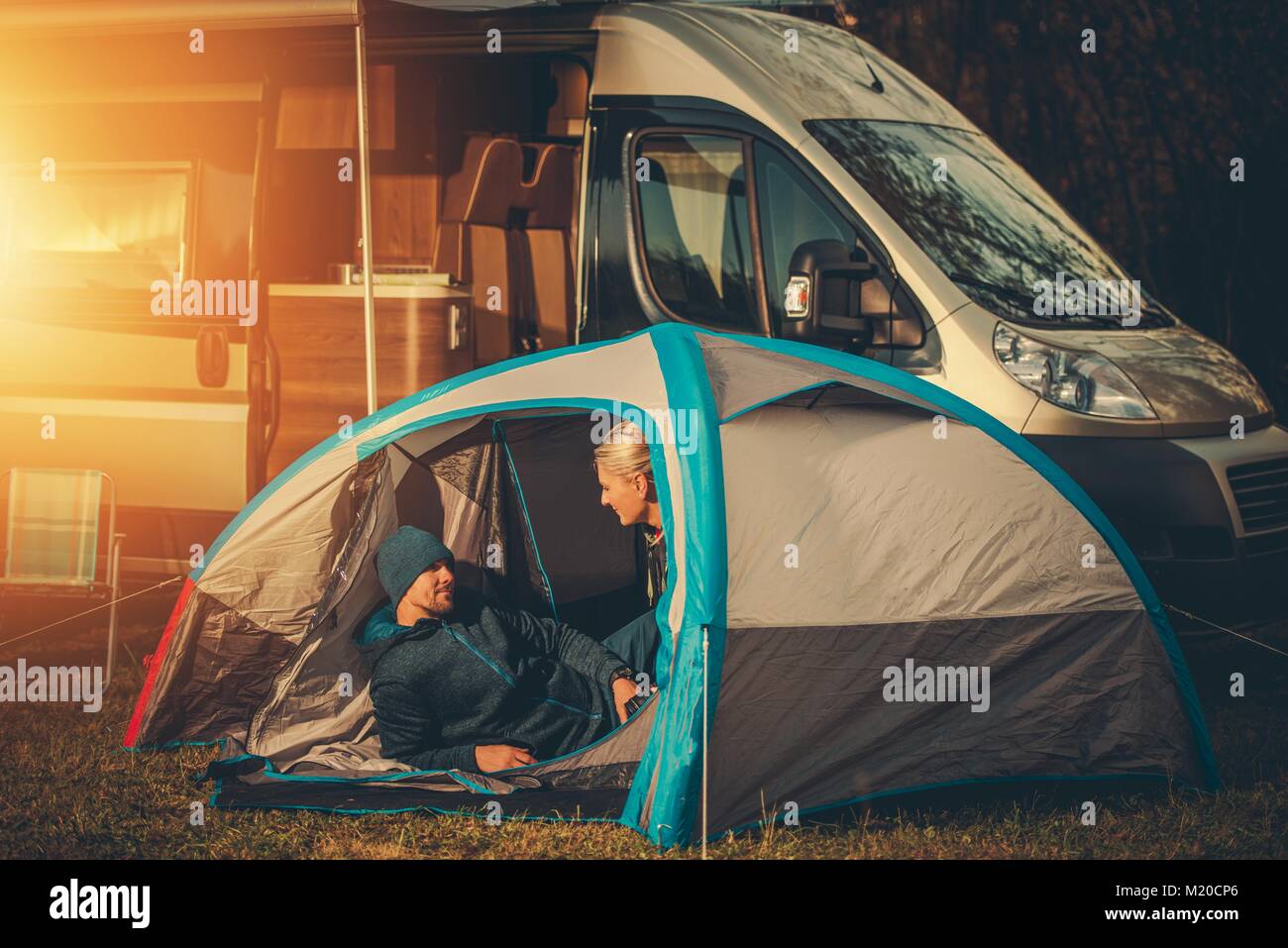 Romantic Tent and RV Camping Spot. Caucasian Couple Having Fun Far From the City. Stock Photo