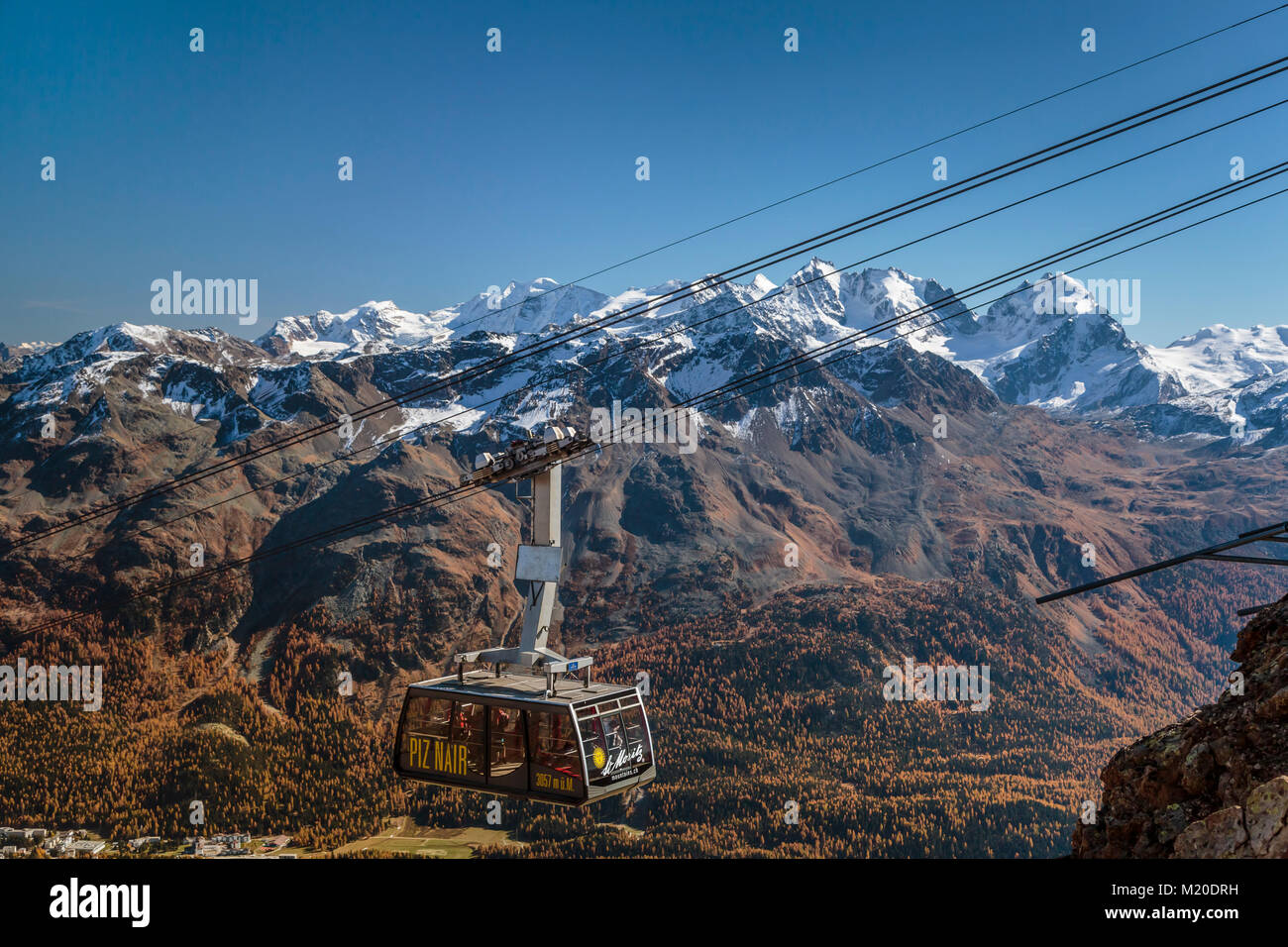 A cable car and the Piz Nair mountain range above St. Moritz ...