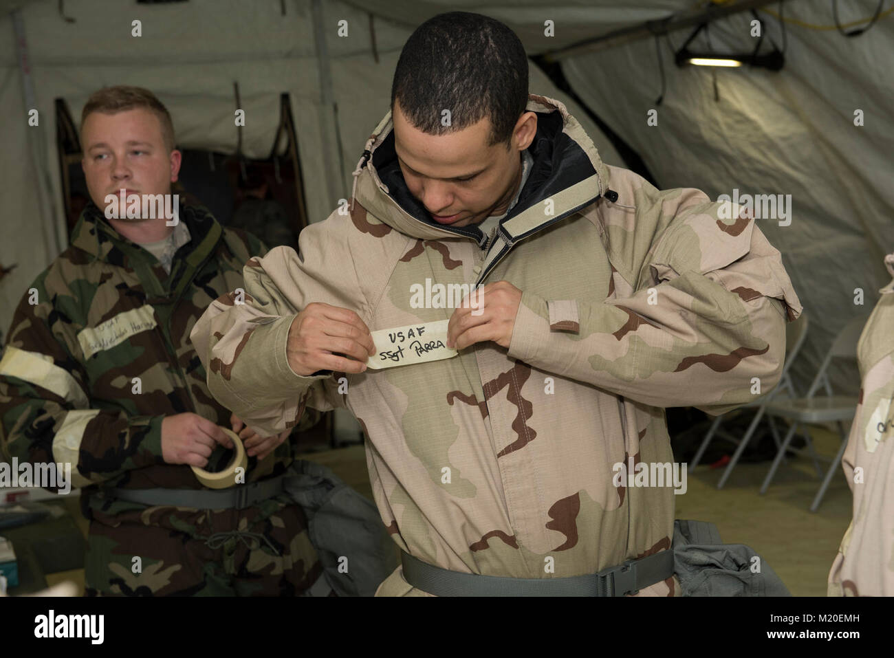 An Airman tapes his name to his mission oriented protective posture