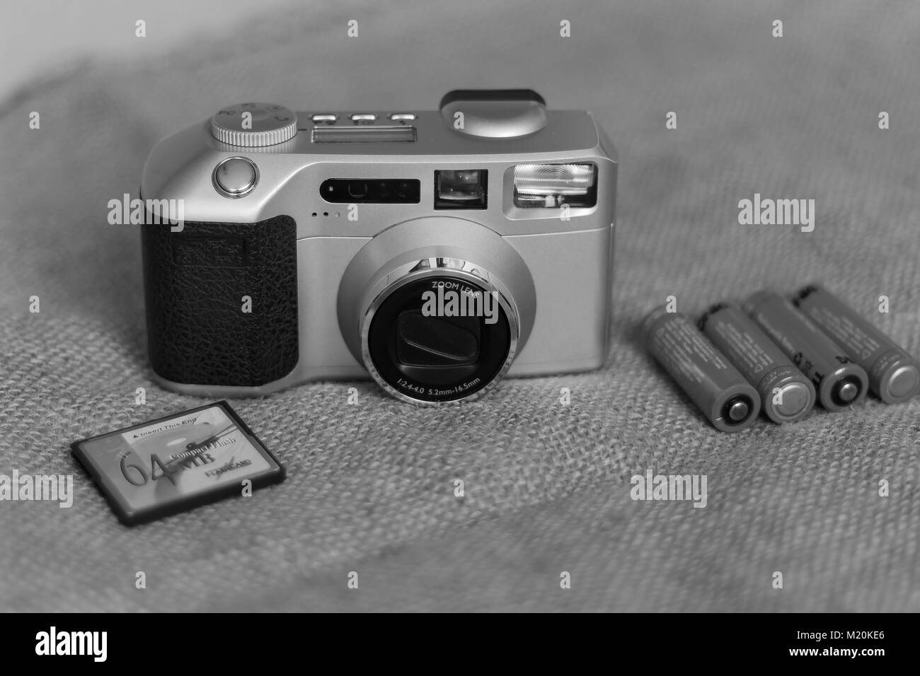Old camera on fabric background with batteries and memory card Stock Photo