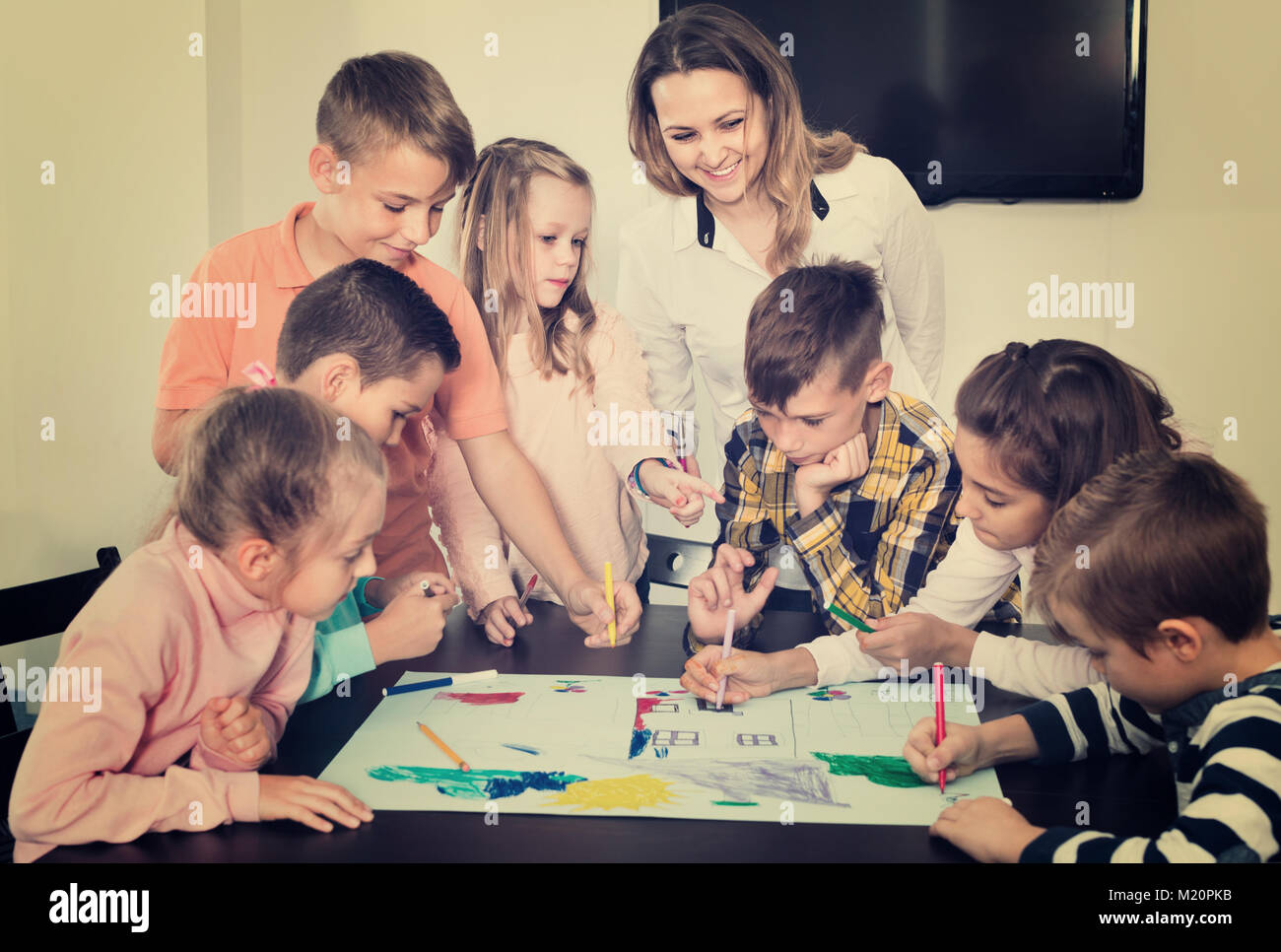 Cute children with teacher drawing together in classroom Stock Photo ...
