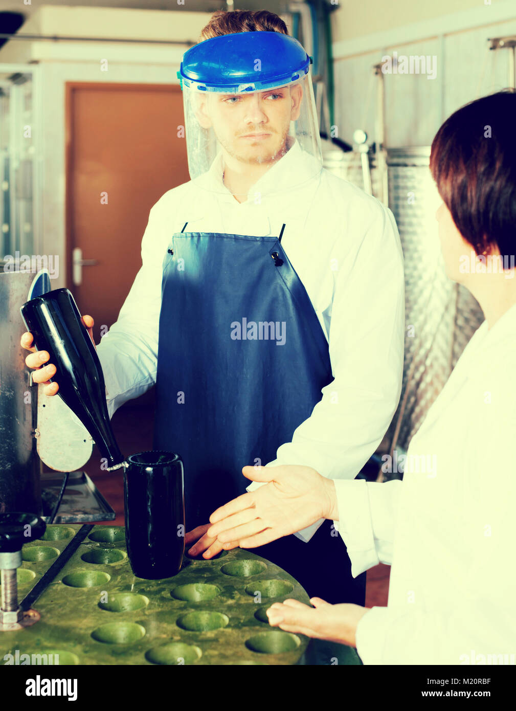 Male worker working with machine at sparkling wine factory Stock Photo