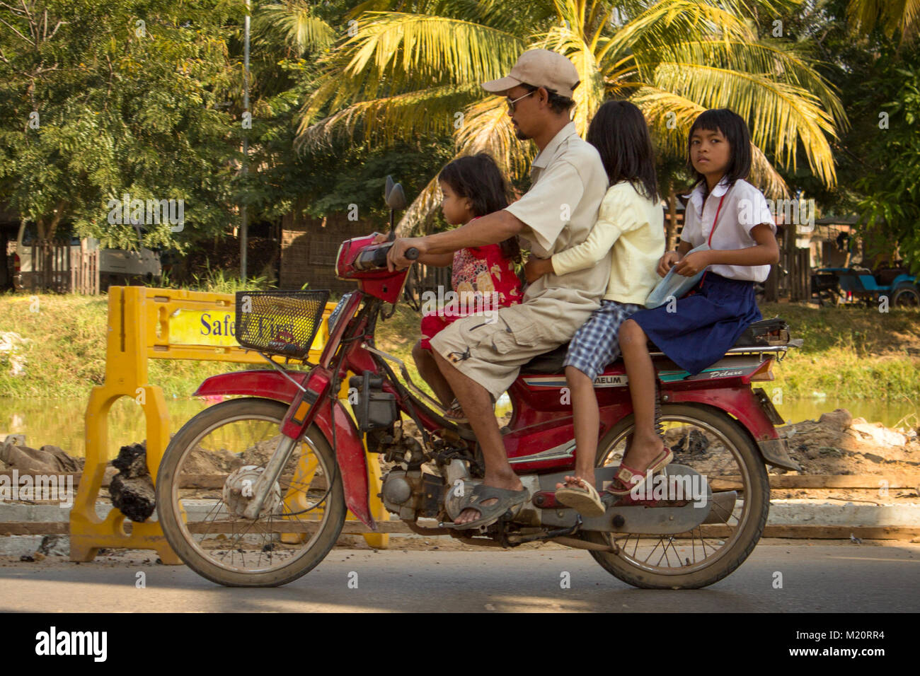 Siem Reap, Cambodia - January 2014: A family of 4 people on a motorbike / scooter driving on the street Stock Photo