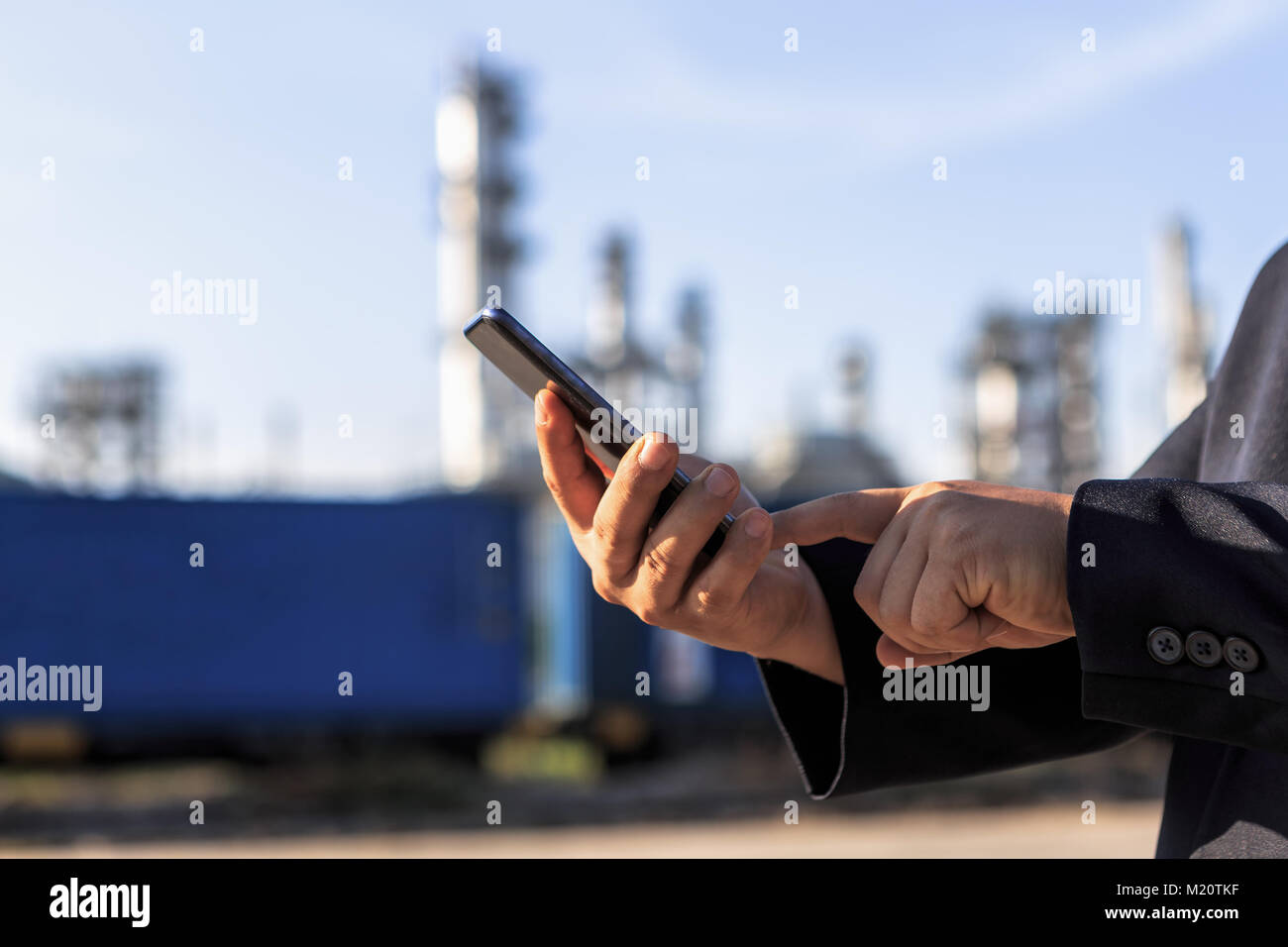 Businessman checking around oil refinery plant with clear sky Stock