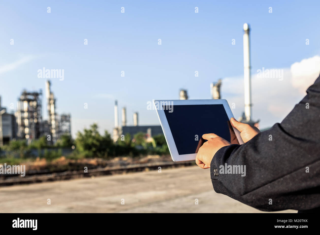 Businessman checking around oil refinery plant with clear sky Stock