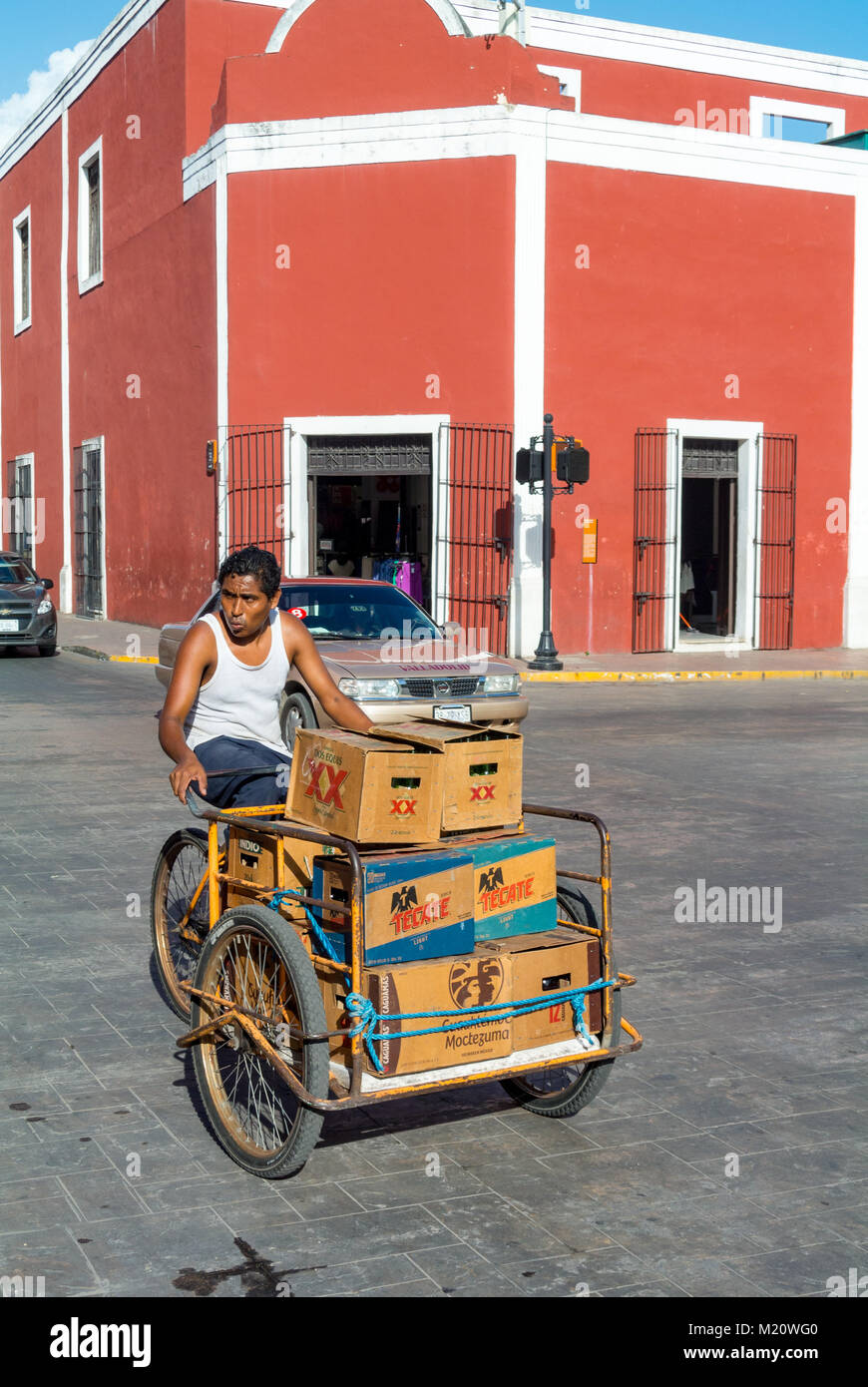 Valladolid, Yucatan, A native man delivering boxes of tecate beers in the street  colonial with red architecture Stock Photo