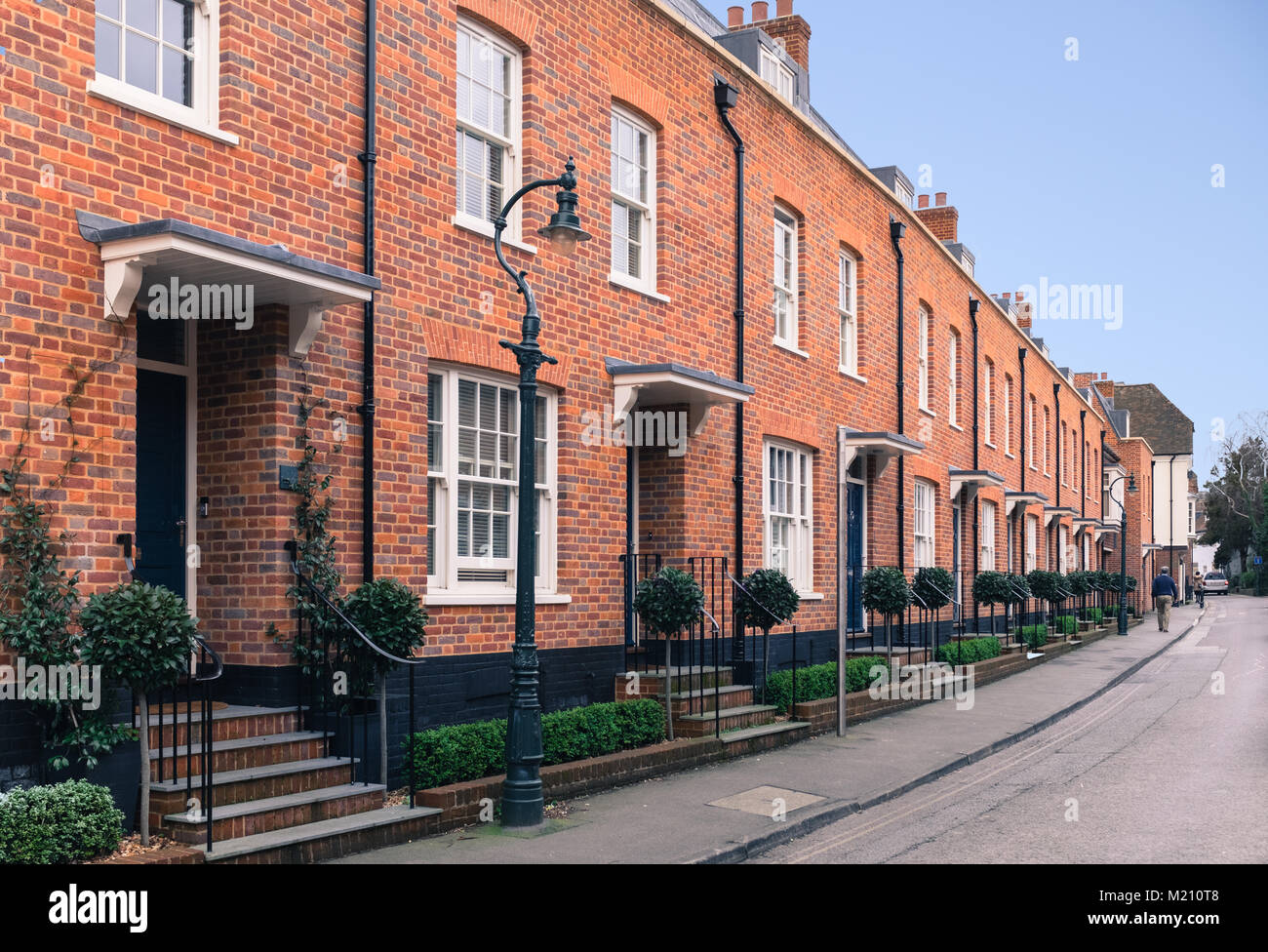 Red brick modern architecture terrace houses ( row houses ) with a retro, vintage Victorian sytle. There a vold fashin style street lamps , sash windo Stock Photo
