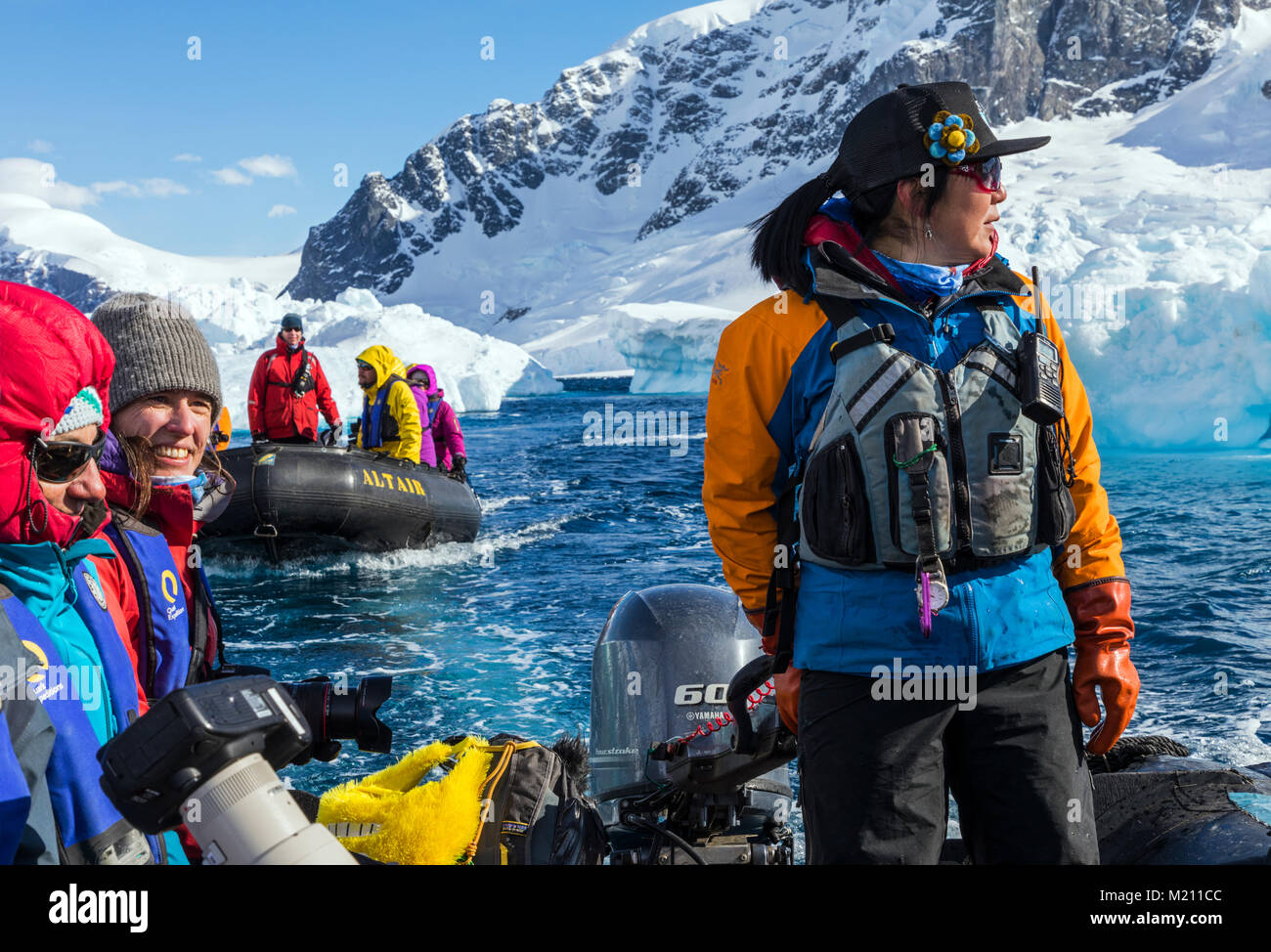 Large inflatable Zodiac boats shuttle alpine mountaineering skiers to Antarctica from the passenger ship Ocean Adventurer; Nansen Island Stock Photo