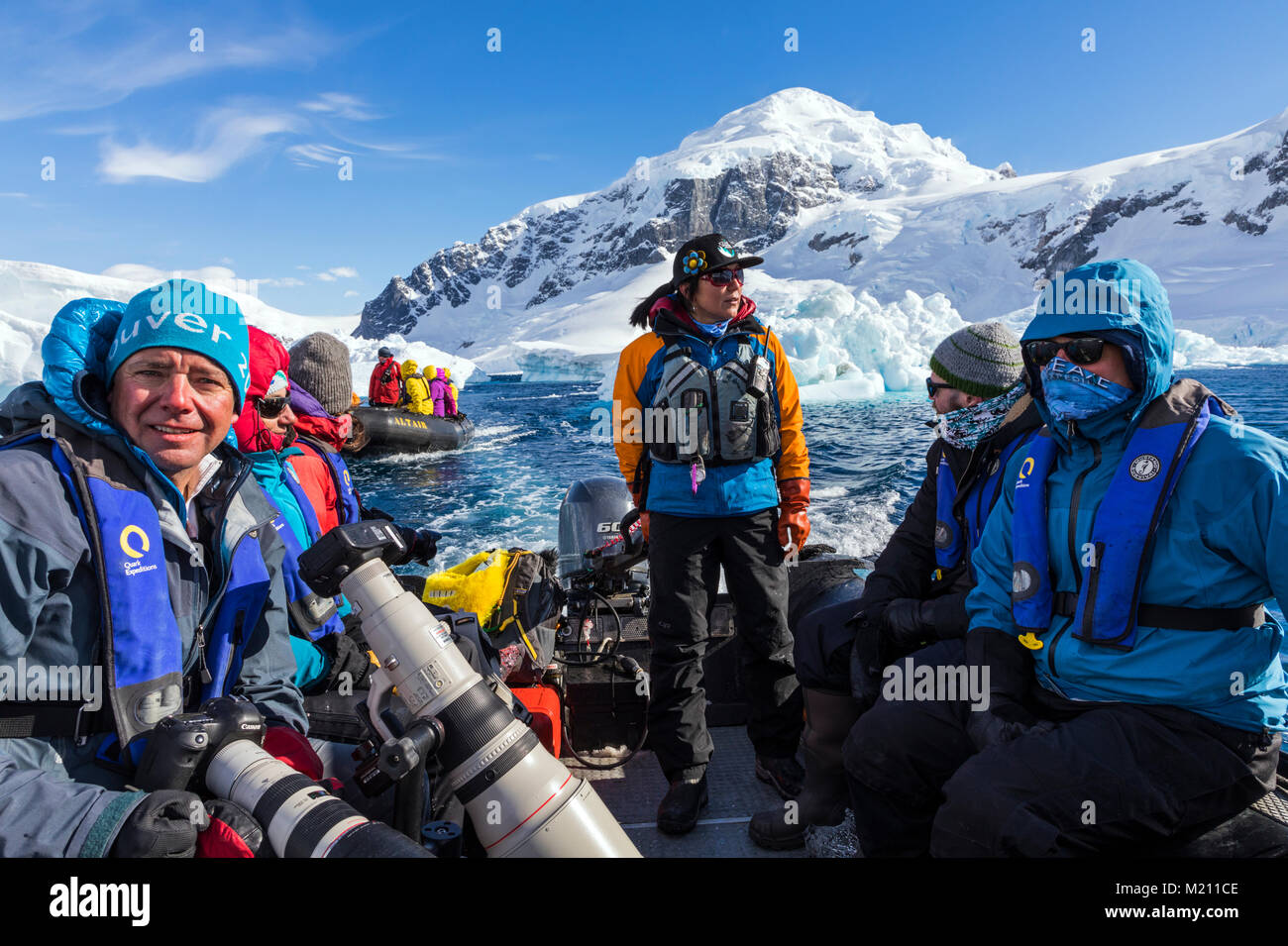 Large inflatable Zodiac boats shuttle alpine mountaineering skiers to Antarctica from the passenger ship Ocean Adventurer; Nansen Island Stock Photo