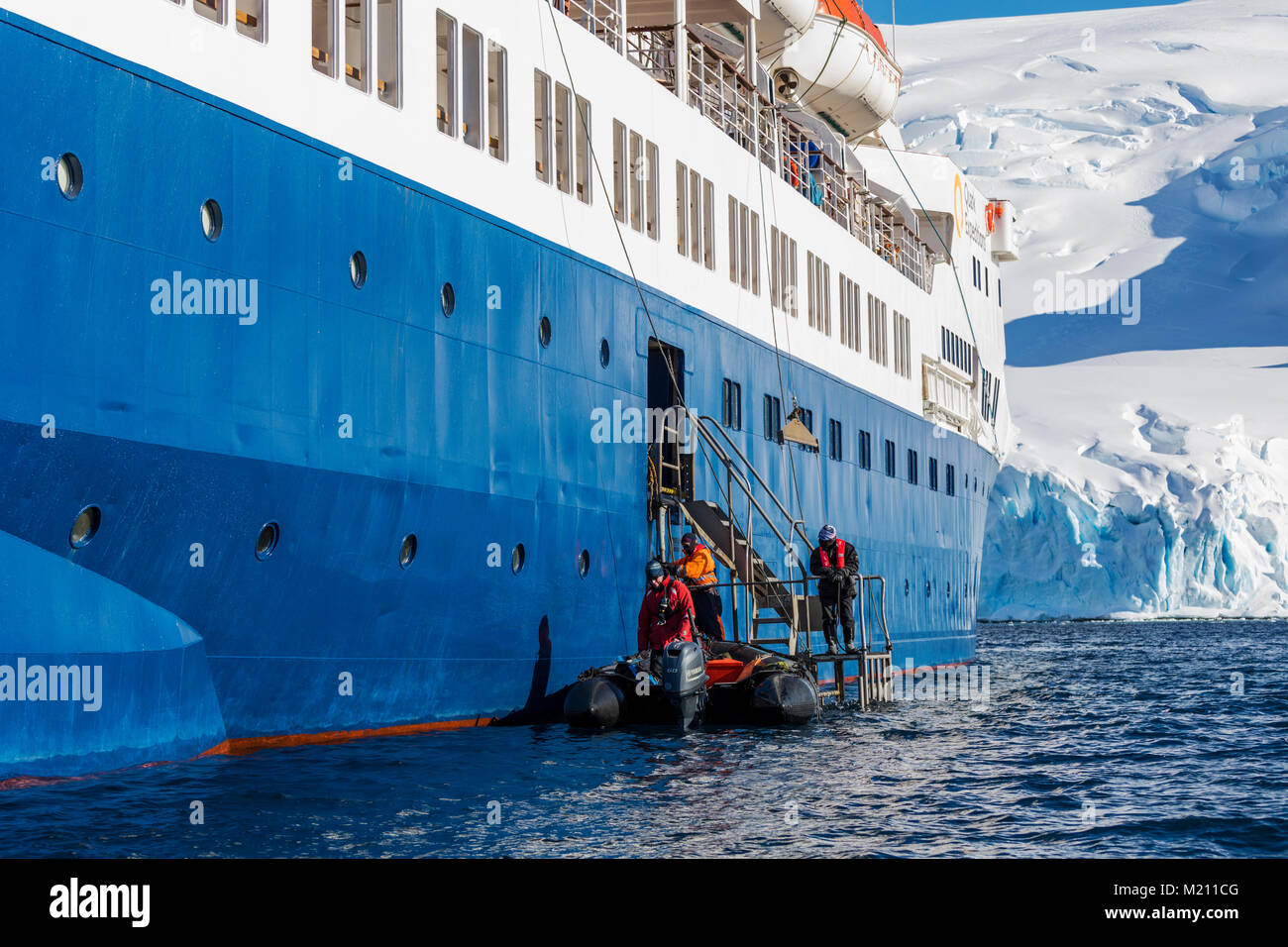 Large inflatable Zodiac boats shuttle alpine mountaineering skiers to Antarctica from the passenger ship Ocean Adventurer; Nansen Island Stock Photo