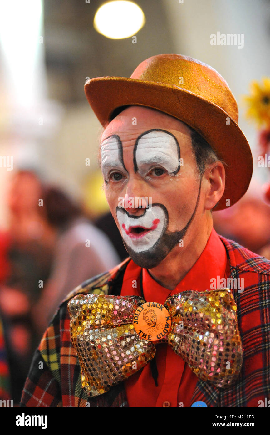 Jolly Jack the Clown singing during the 67th Annual Grimaldi Clown Church Service at Holy Trinity Church, Dalston, East London.  The service, which has been an annual tradition since 1946, is held in memory of Joseph 'Clown Joey' Grimaldi (1778-1837), the most celebrated English clown who was born and performed in London.  The unique church service is held on the first Sunday of each February and a wreath is laid in Grimaldi's honour. Stock Photo