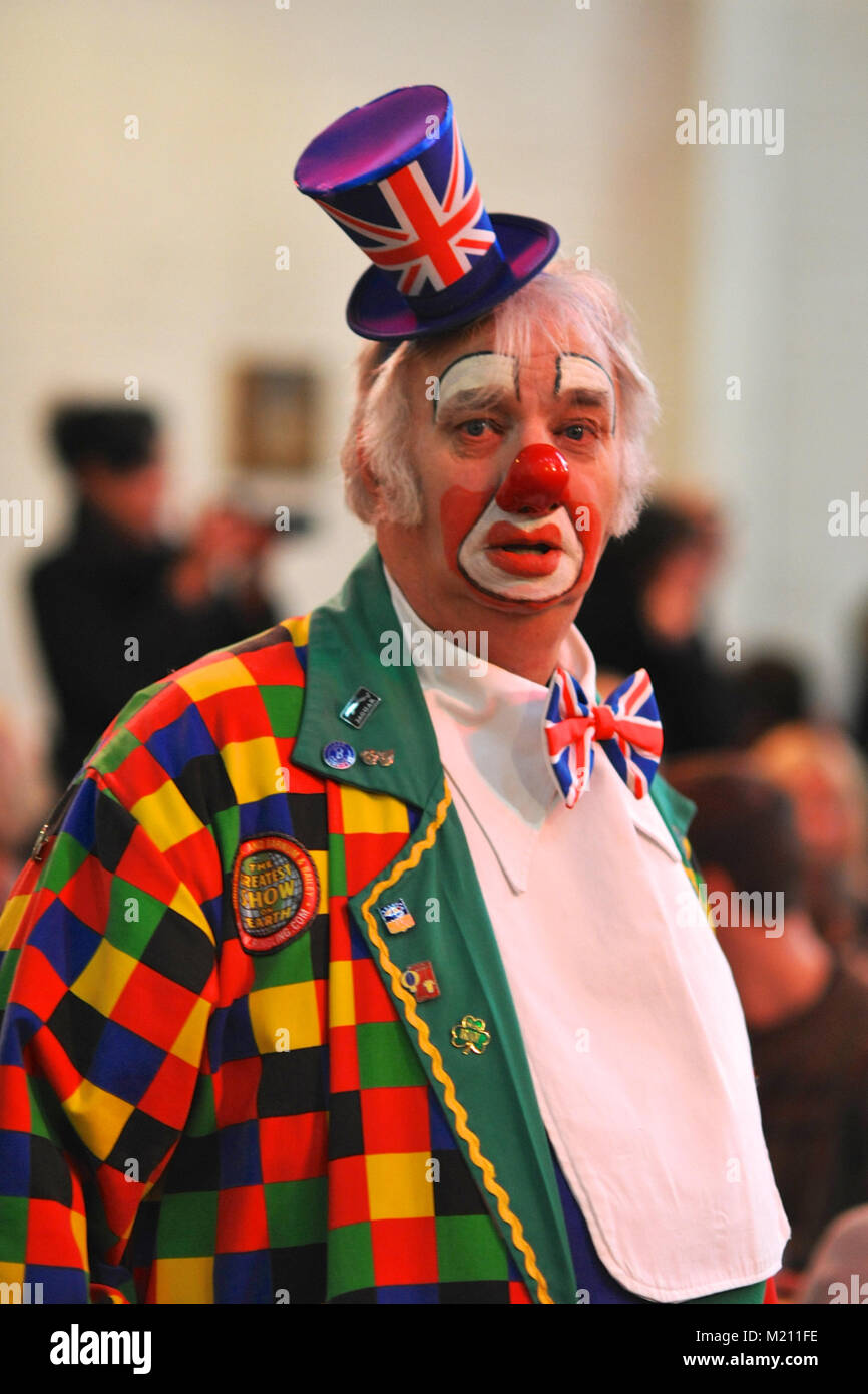 A clown looking rather patriotic just before the start of the 67th Annual Grimaldi Clown Church Service at Holy Trinity Church, Dalston, East London.  The service, which has been an annual tradition since 1946, is held in memory of Joseph 'Clown Joey' Grimaldi (1778-1837), the most celebrated English clown who was born and performed in London.  The unique church service is held on the first Sunday of each February and a wreath is laid in Grimaldi's honour. Stock Photo