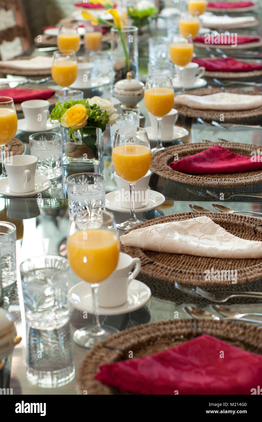 A glass table set for brunch with glasses, cups, saucers, utensils ... A glass table set for brunch with glasses, cups, saucers, utensils ...