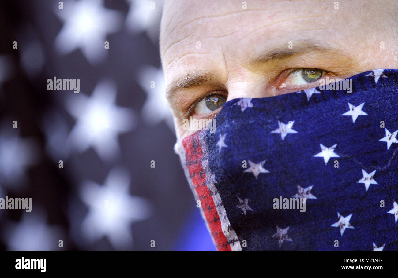 San Diego, CA, USA. 3rd Feb, 2018. An attendee aligned with the Patriotic Picnic looked across to Chicano Park in the Barrio Logan neighborhood of San Diego Saturday morning while protestors rallied against them. Credit: John Gastaldo/ZUMA Wire/Alamy Live News Stock Photo