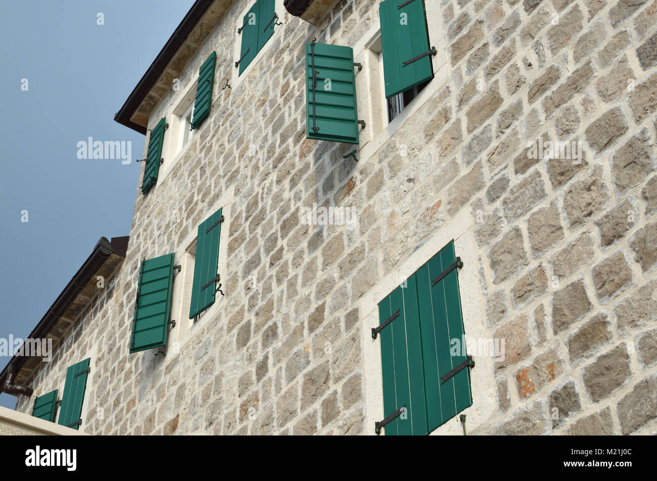 Open and closed wooden shutters on a house facade made of stone Stock ...
