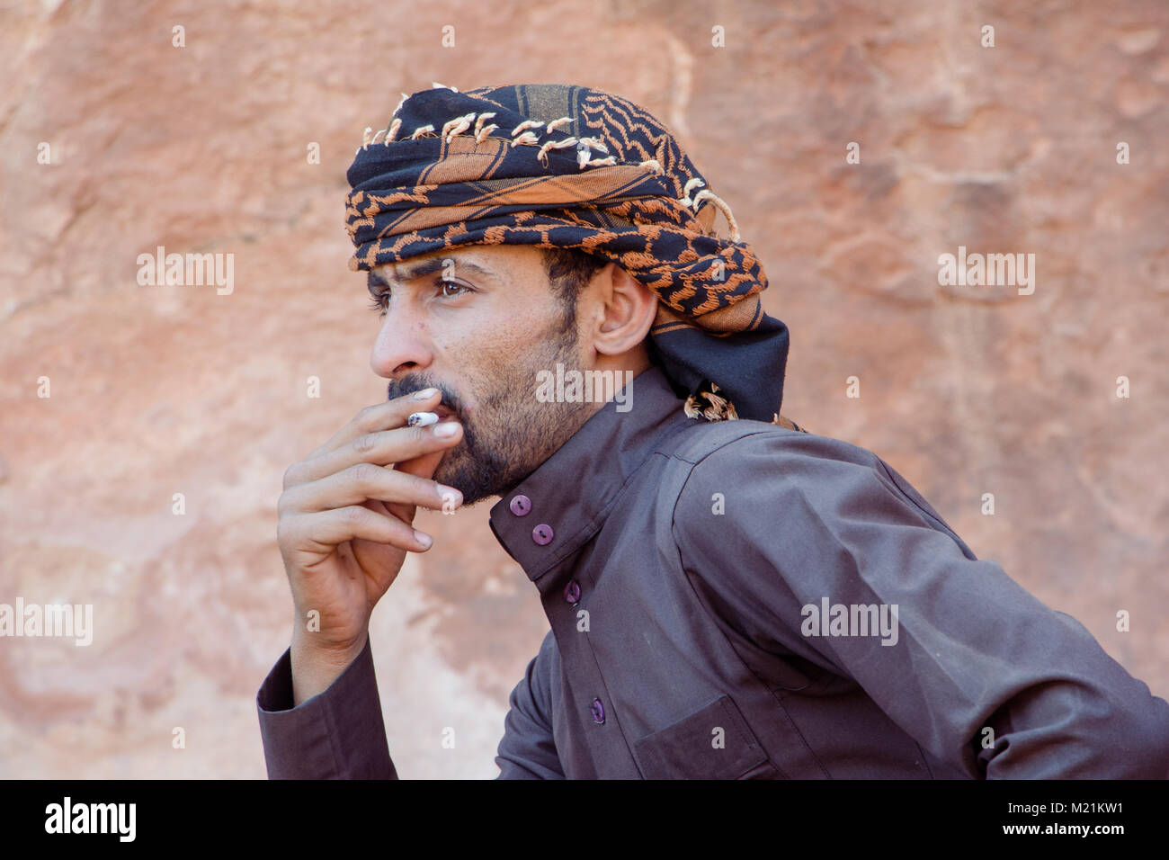WADI RUM CAMP, JORDAN - APRIL 30, 2016:  Bedouin man in Wadi Rum smoking a cigarette Stock Photo