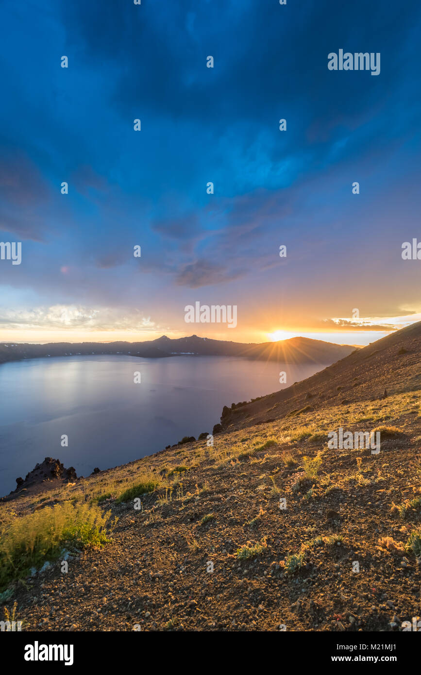 Sunbursts Over The Rim Of Crater Lake in summer afternoon Stock Photo