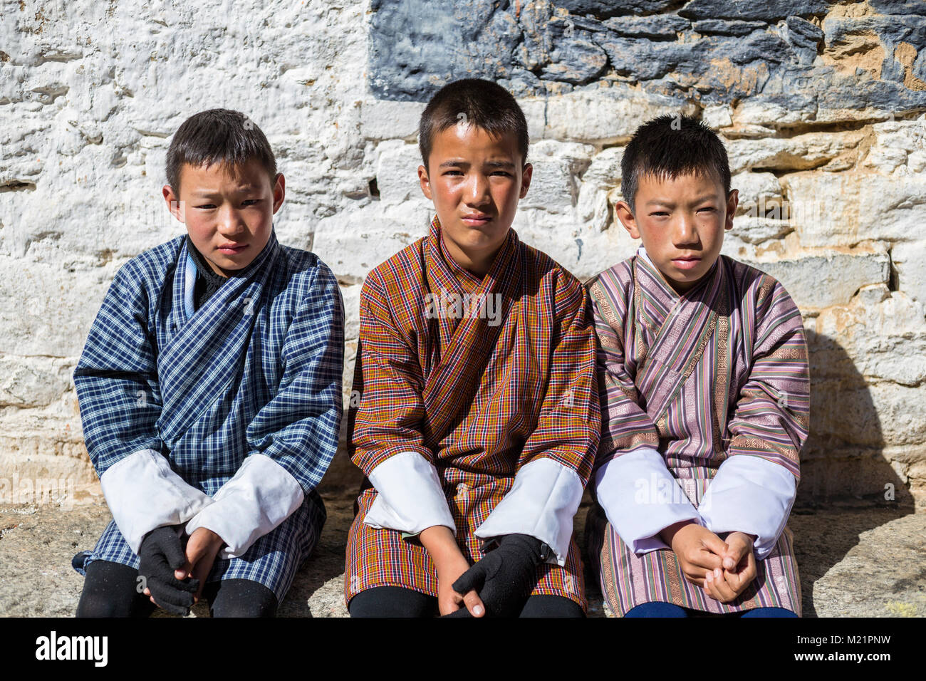 Prakhar Lhakhang, Bumthang, Bhutan.  Three Young Bhutanese Boys Wearing their Traditional Gho. Stock Photo
