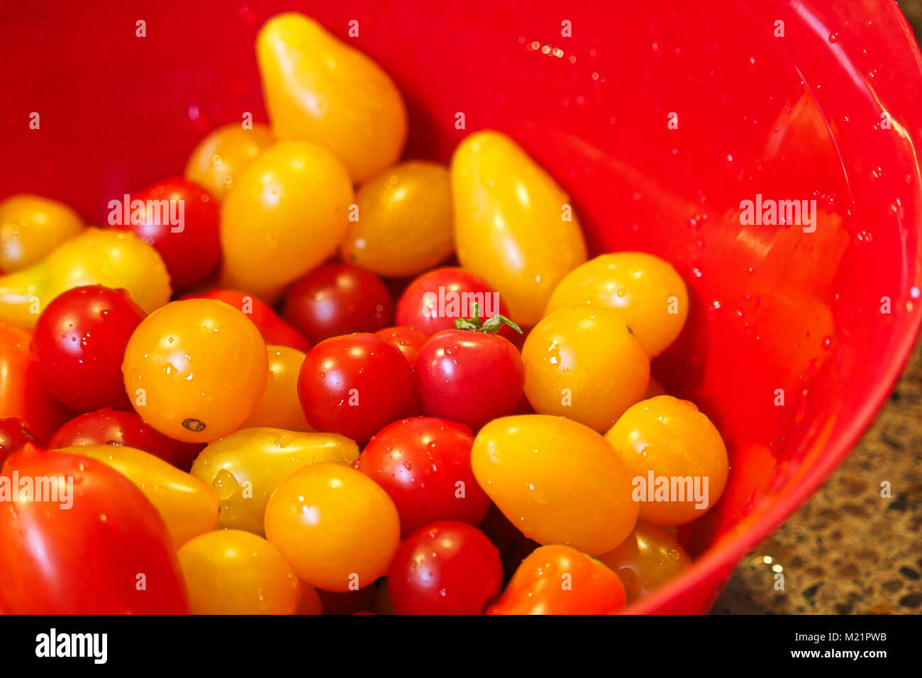 Closeup of cherry tomatoes in a red bowl Stock Photo - Alamy