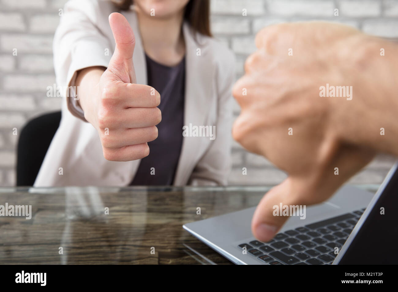 Close-up Of A Businesswoman Showing Thumbs Up To Her Colleague At Workplace In Office Stock Photo