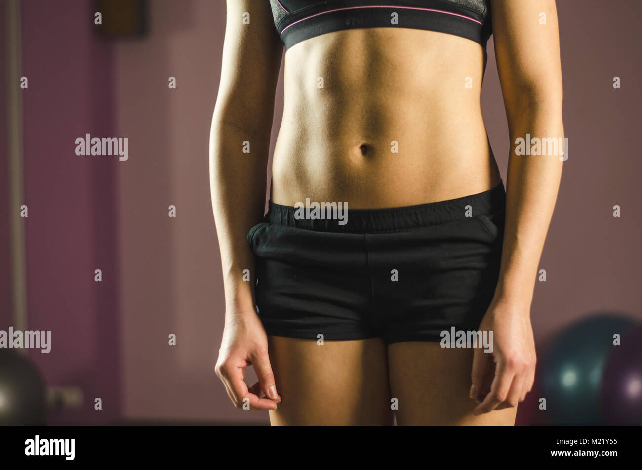 Foto de Cropped shot of a young slim woman in underwear with toned stomach  demonstrating her abs isolated on a white background. Result of fitness,  diet, healthy lifestyle. Female belly after a