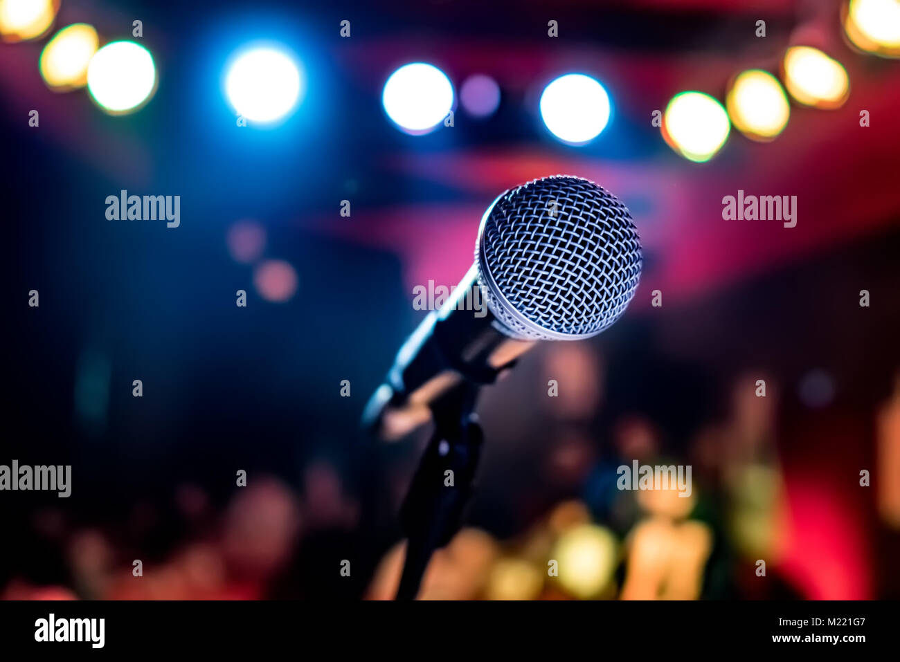 Public performance on stage Microphone on stage against a background of auditorium. Shallow depth of field. Public performance on stage. Stock Photo