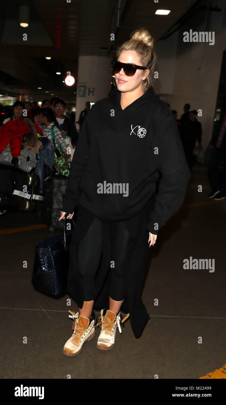 Pregnant Khloe Kardashian at Los Angeles International Airport LAX wearing a baggy black hoodie to hide her baby bump sunglasses and open laced Timberland beige boots Featuring Khloe Kardashian Where ...