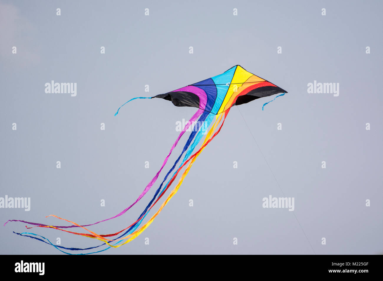 Rainbow colored kite with a long tail at International Kite Festival