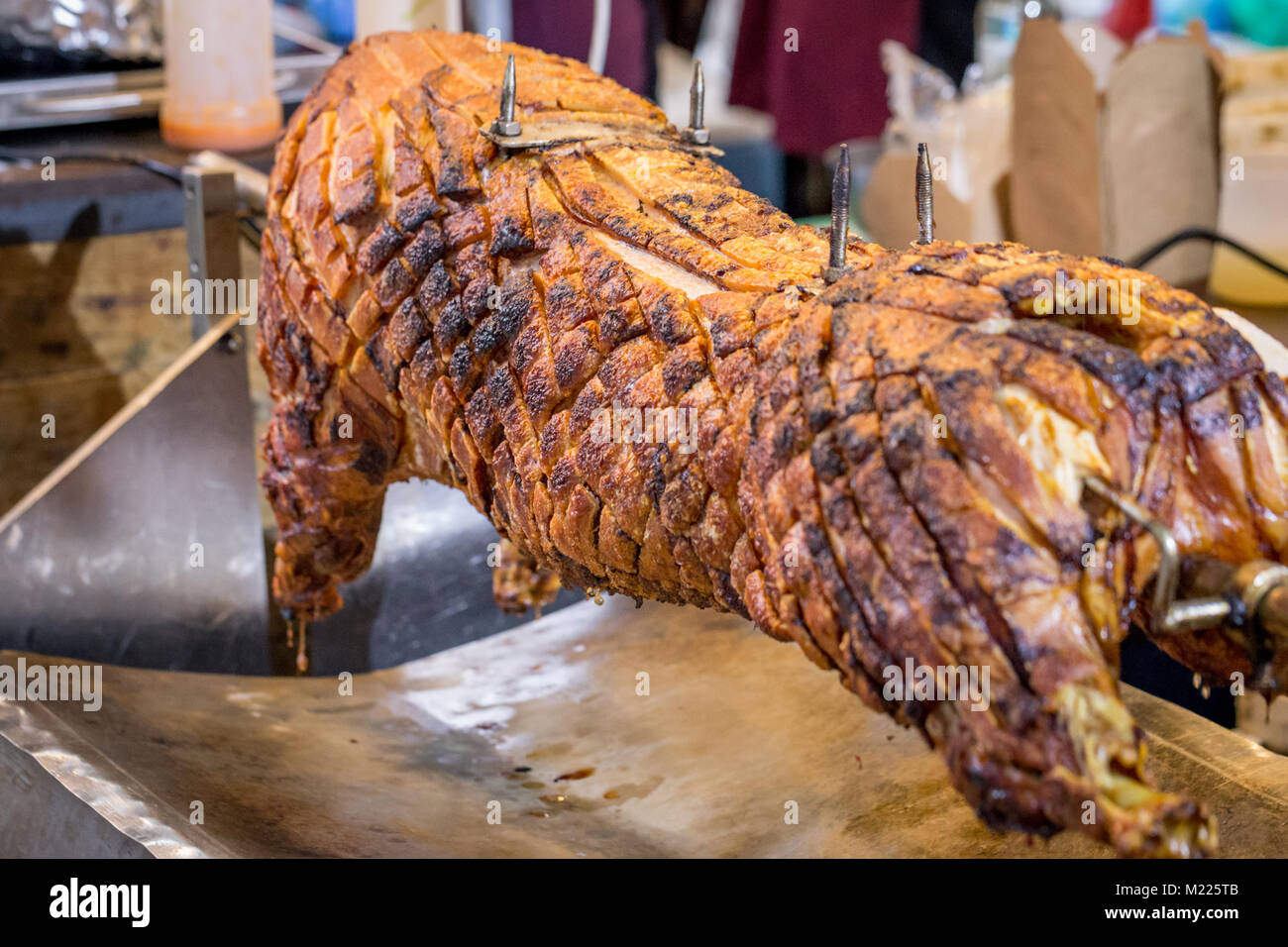 A spit roasted pig on a market stall in Borough Market, London Stock Photo