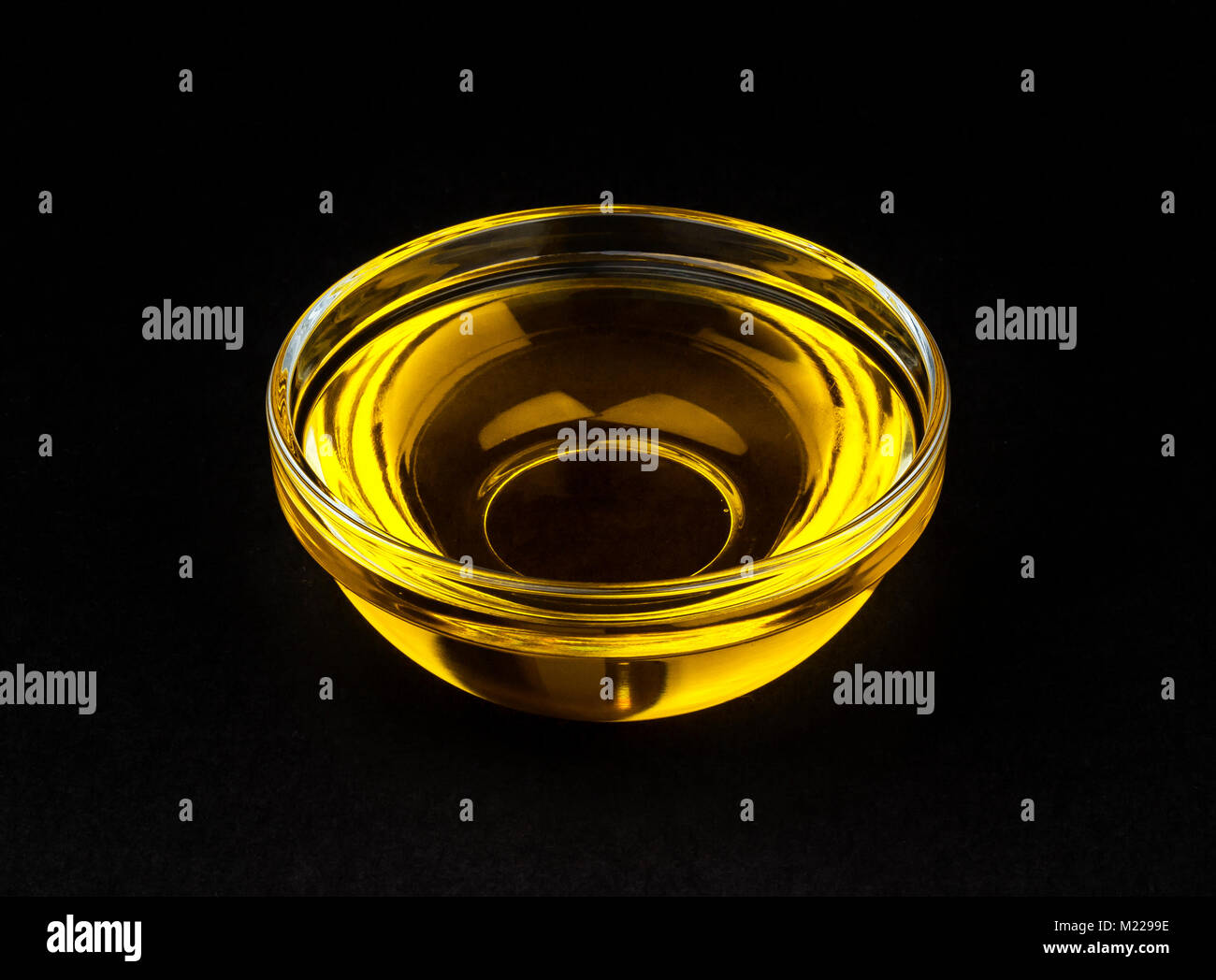 Vegetable oil in bowl on black background Stock Photo