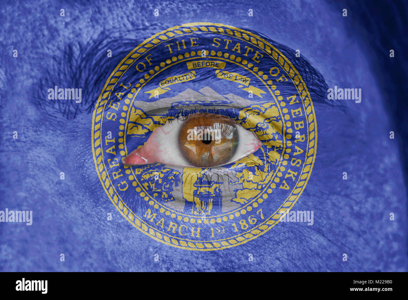 Human face and eye painted with US state flag of Nebraska Stock Photo