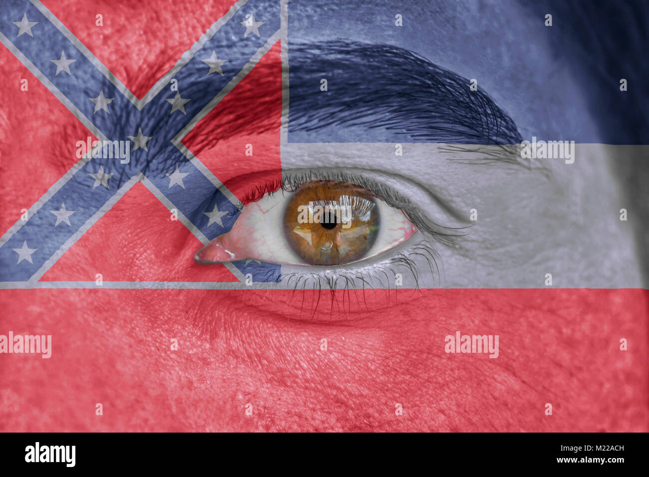 Human face and eye painted with US state flag of Mississippi Stock Photo