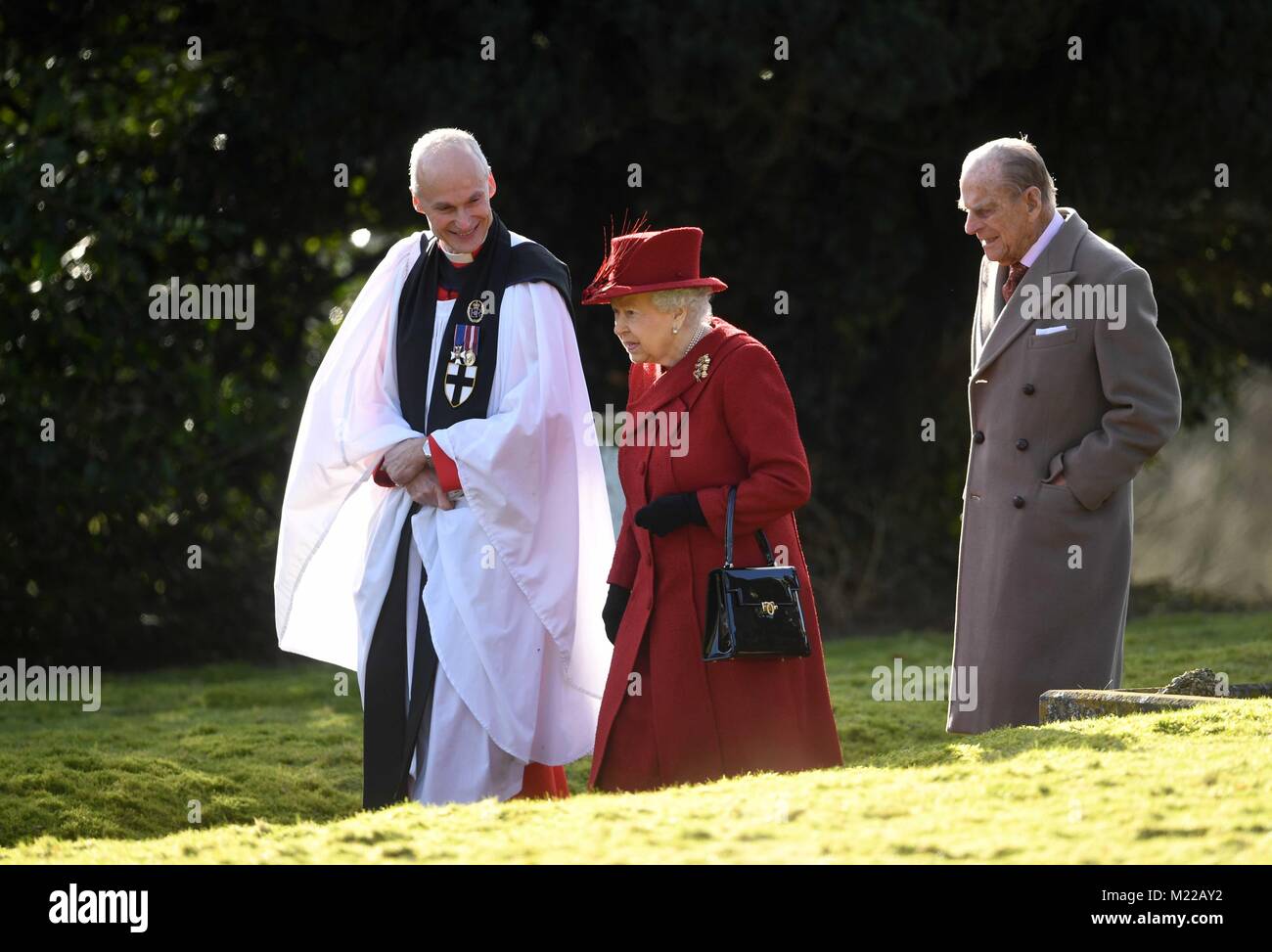 Queen Elizabeth II and the Duke of Edinburgh with Canon Jonathan Riviere (left) as they attended St Peter and Paul Church in West Newton, Norfolk, for a Sunday morning service. Stock Photo