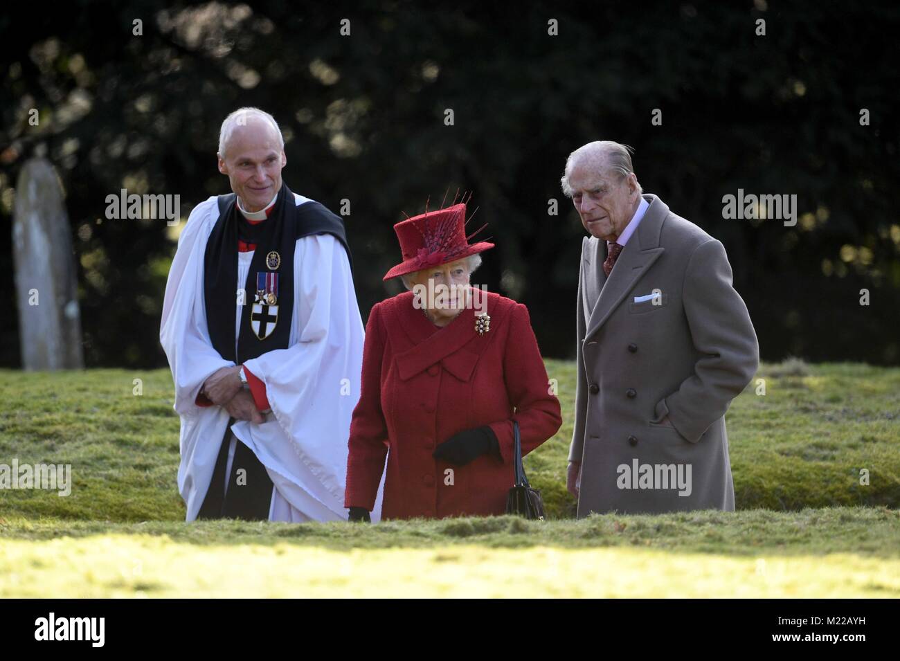 Queen Elizabeth II and the Duke of Edinburgh with Canon Jonathan Riviere (left) as they attended St Peter and Paul Church in West Newton, Norfolk, for a Sunday morning service. Stock Photo
