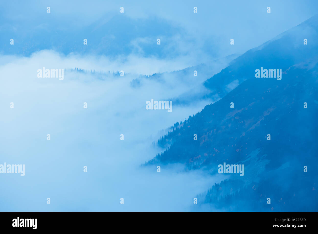 foggy mountain landscape with clouds above the peaks Stock Photo - Alamy