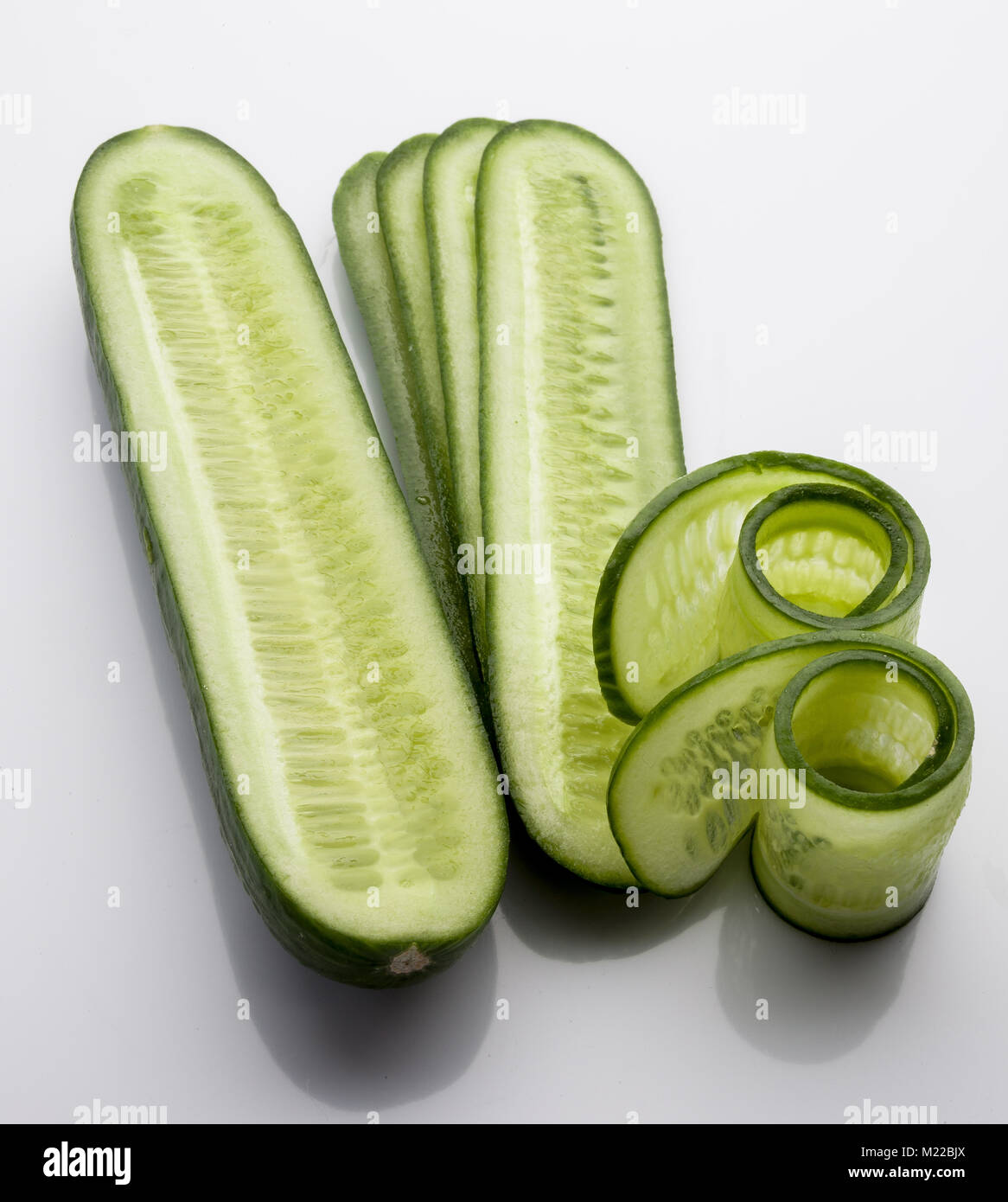 Sliced and rolled fresh cucumber on white background vertical from