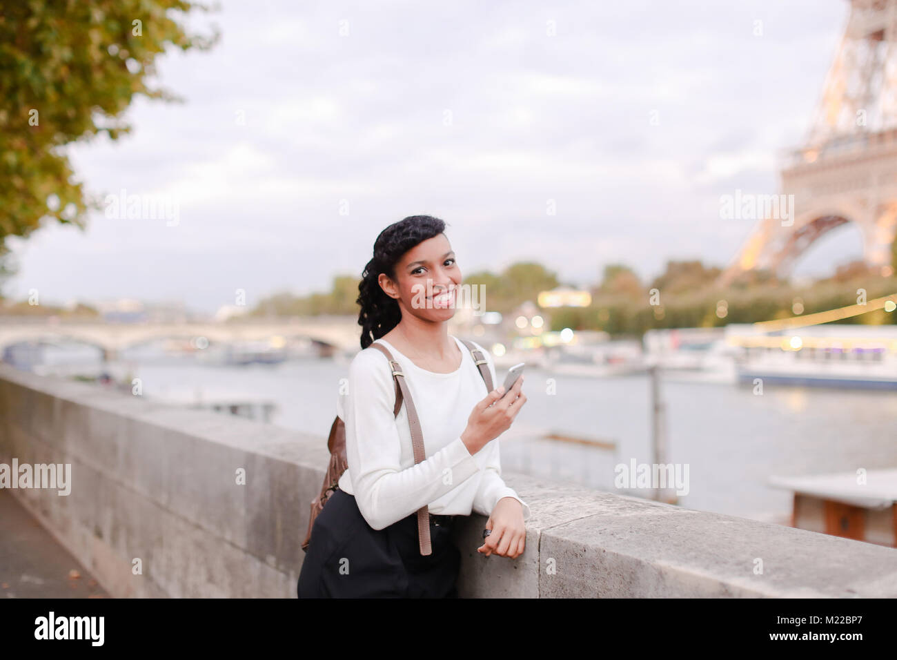 Smiling business woman standing on bridge and using smartphone Stock ...