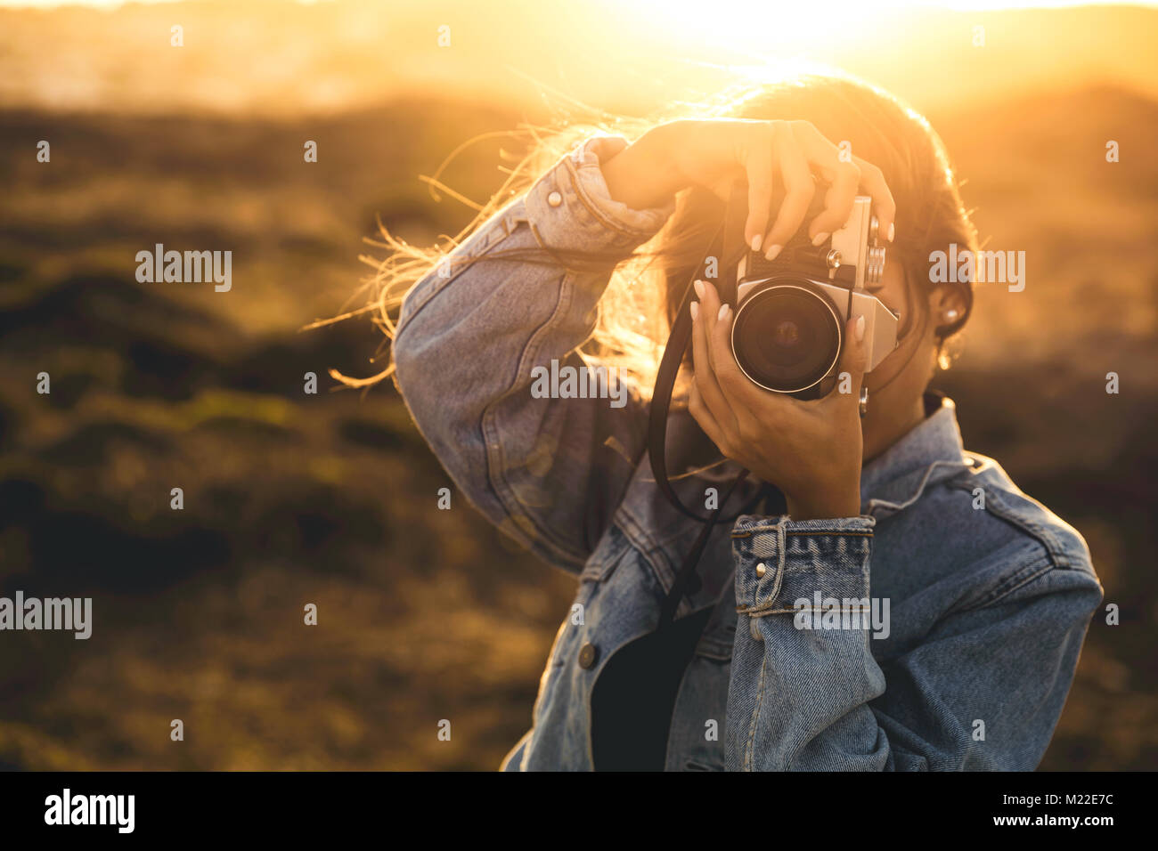 Beautiful woman taking picture outdoors with a analog camera Stock Photo