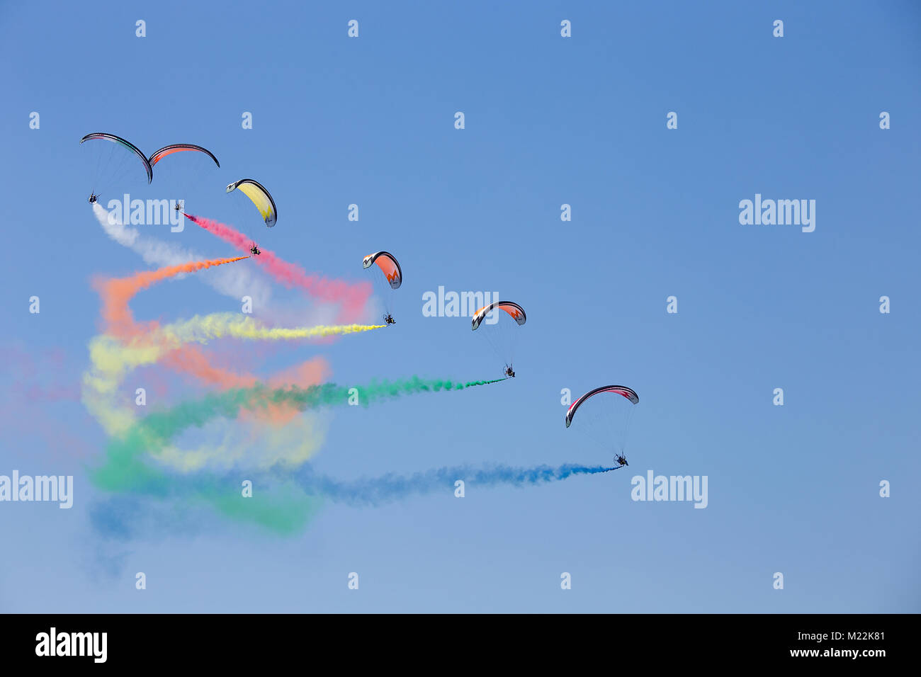 Powered parachutes Air show - multicolored Paratroopers in the sky during aircraft exhibition with trail of italian flag colors over Grado beach, Ital Stock Photo
