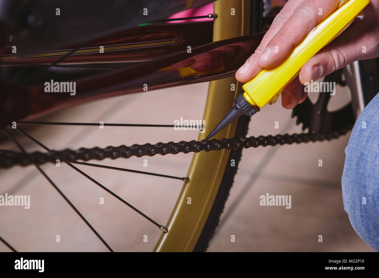 Theme repair bikes. Closeup of a Caucasian man's hand use a Chain Lubricant in a yellow