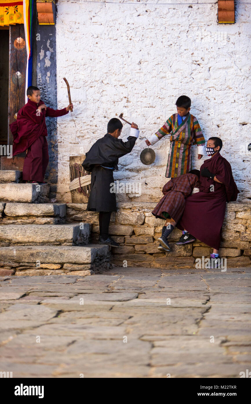 Prakhar Lhakhang, Bumthang, Bhutan.  Young Boys Striking Drum and Gong during Monks' Performance of the Bhutanese Religious Duechoed Festival. Stock Photo
