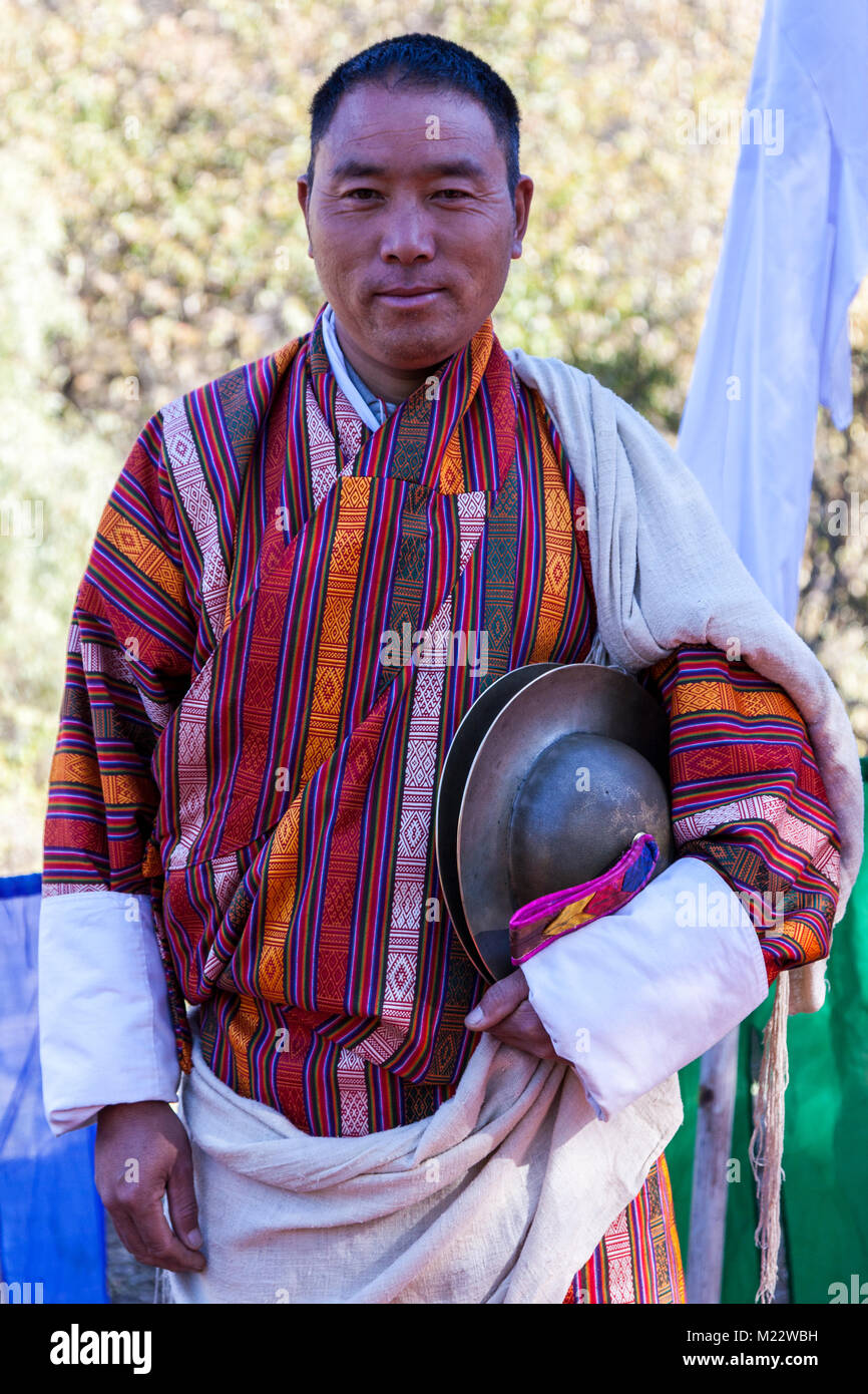 Prakhar Lhakhang, Bumthang, Bhutan.  Man Wearing Traditional Gho Holding Cymbals as he Prepares to Welcome the King. Stock Photo