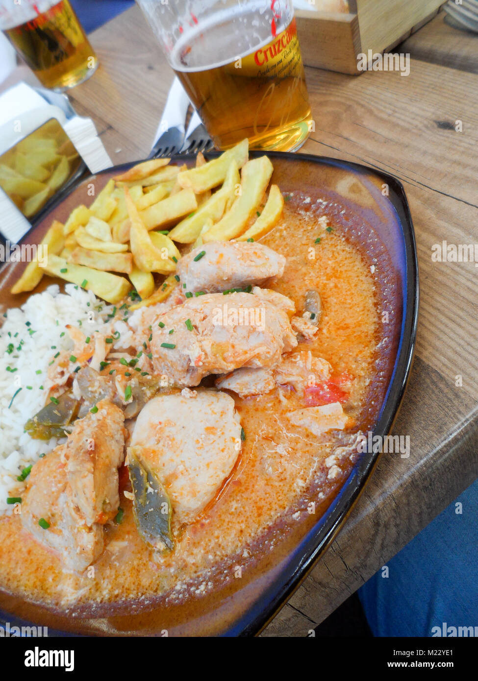 Chicken  Stroganof with boiled rice and potato chips/fries taken in a Tapas bar in Fuengirola, Spain Stock Photo
