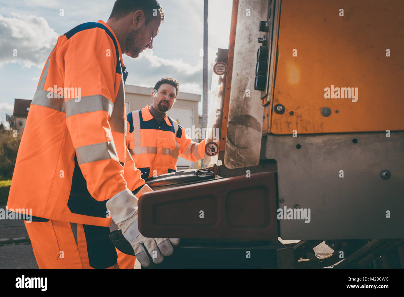 Garbage removal men working for a public utility Stock Photo Alamy