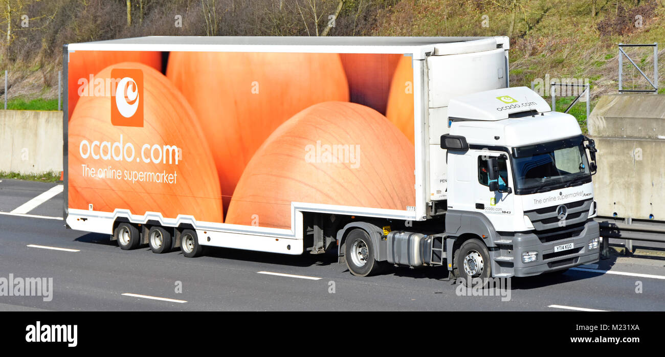 Ocado online shopping  & internet grocery firms food supply chain trailer with onion graphics & hgv delivery lorry truck driving along UK m25 motorway Stock Photo