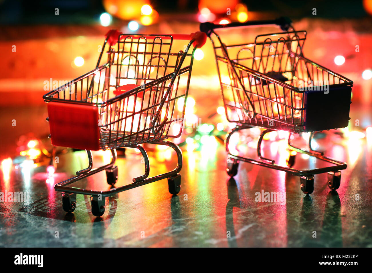 metal supermarket small cart on a background colored lights Stock Photo