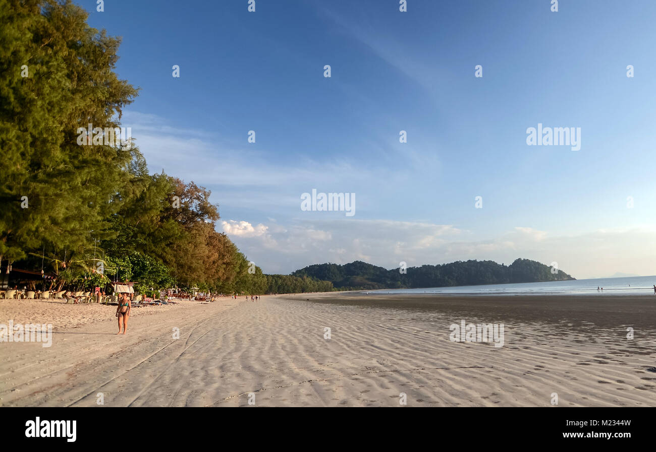 Koh Phayam, Thailand - January 9, 2016: Long beach or Aow yai beach in Koh Phayam, Thailand, touristic island, tourists walking and sitting on the bea Stock Photo